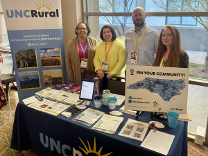 UNC Rural exhibitor table with Melissa, Gabby, Adam and Gail at the Rural Summit in Raleigh, NC during Rural Week